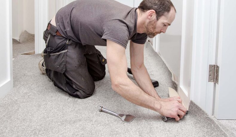 Man fitting a grey carpet